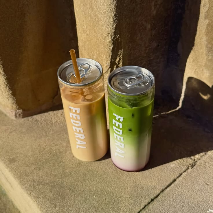 Two branded cans of iced latte and matcha in the sun