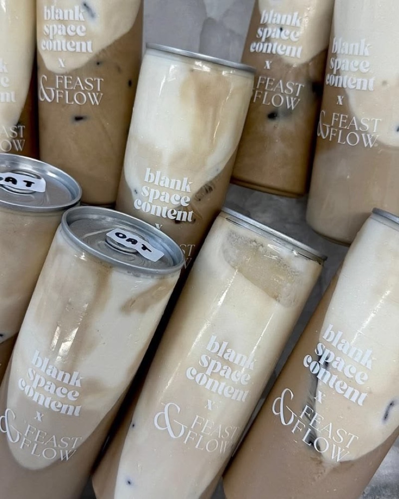 A pile of printed oat latte cans
